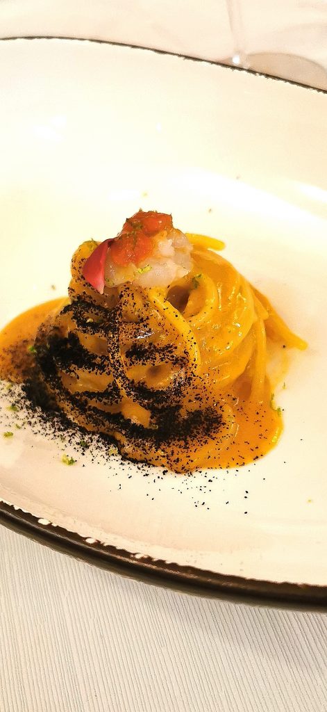 Spaghetti di Gragnano ai ricci di mare, polvere di aglio nero e tartare di scampo trattoria la madia